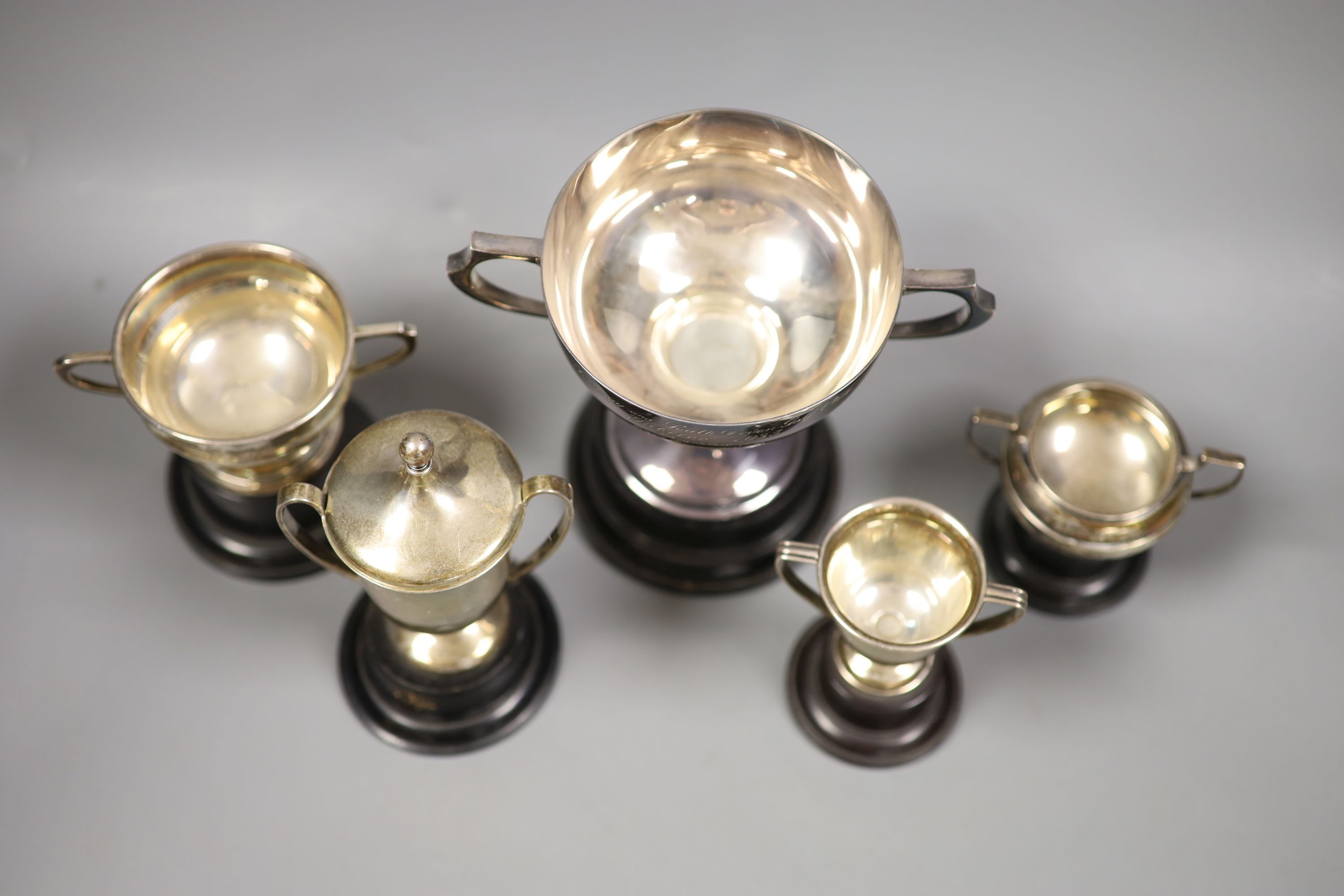 A collection of five small silver presentation trophy cups